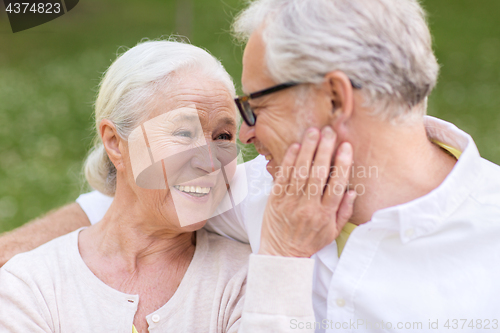 Image of happy senior couple sitting on bench at park