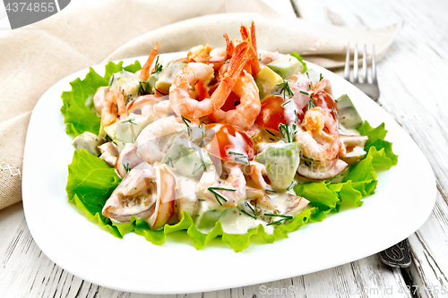 Image of Salad with shrimp and tomato in plate on light board