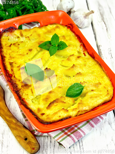 Image of Gratin potato with fish in brazier on board