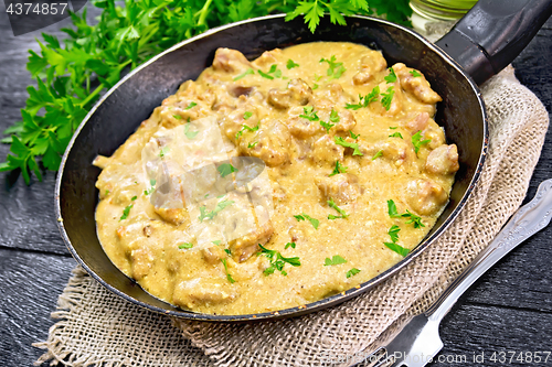 Image of Meat stewed with cream in pan on board