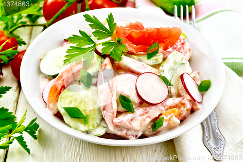 Image of Salad from fresh vegetables and greens in plate on light board