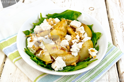 Image of Salad from pear and spinach with feta in dish on light board