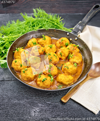 Image of Meatballs in pan with sauce on black board