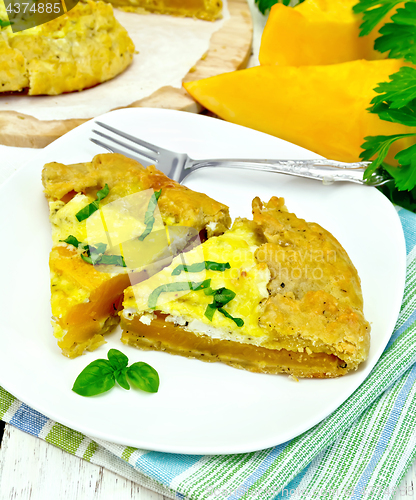 Image of Pie of pumpkin and basil in plate on board