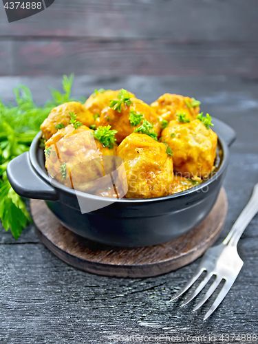 Image of Meatballs in black brazier with greens on board