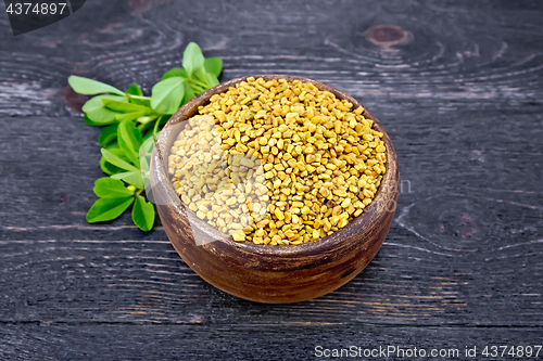 Image of Fenugreek with green leaf in clay bowl on board