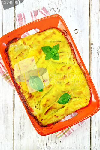 Image of Gratin potato with fish in brazier on board top