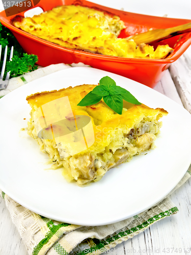 Image of Gratin potato with fish in plate on napkin