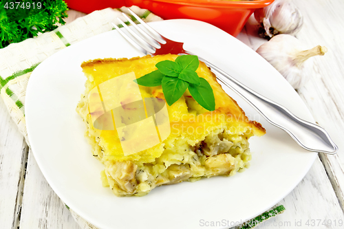 Image of Gratin potato with fish in plate on board