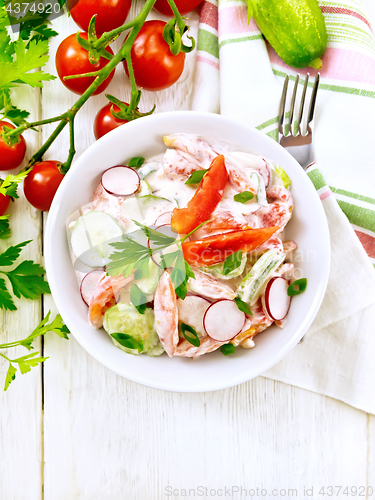 Image of Salad from fresh vegetables in plate on light board top