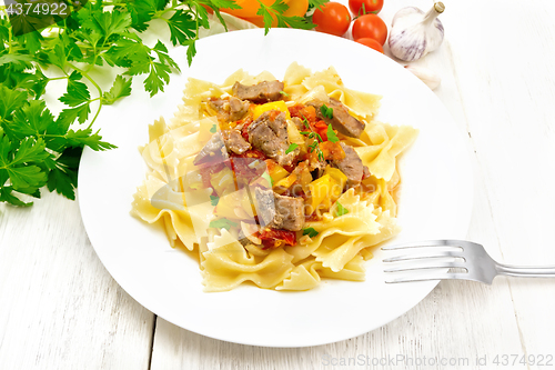 Image of Farfalle with turkey and vegetables in plate on board