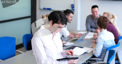 Image of Businesswoman using tablet with coworkers in backgorund having m