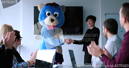 Image of boss dresed as bear having fun with business people in trendy of