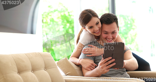 Image of Young Couple using digital tablet at home