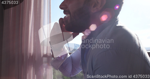 Image of Business Man Talking On Cell Phone At Home