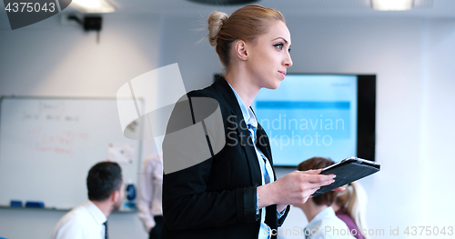 Image of Businesswoman using tablet with coworkers in backgorund having m