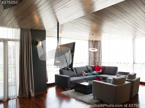 Image of Man using laptop in living room