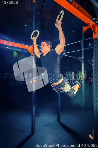 Image of Concept: power, strength, healthy lifestyle, sport. Powerful attractive muscular man at CrossFit gym