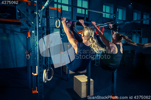 Image of Concept: power, strength, healthy lifestyle, sport. Powerful attractive muscular women at CrossFit gym