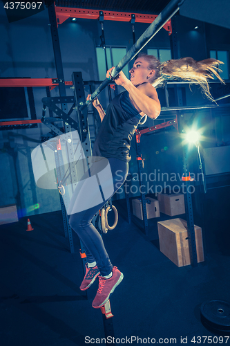 Image of Concept: power, strength, healthy lifestyle, sport. Powerful attractive muscular woman at CrossFit gym