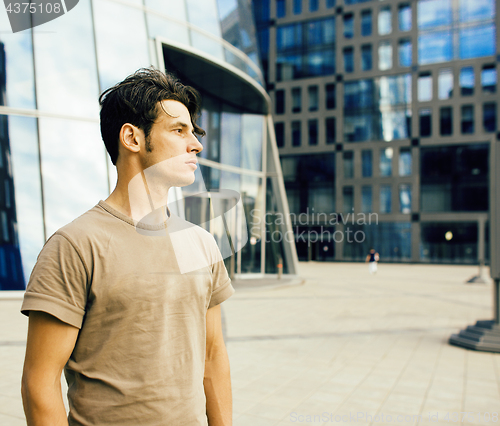 Image of young handsome hipster guy outside infront of business building, lifestyle people concept