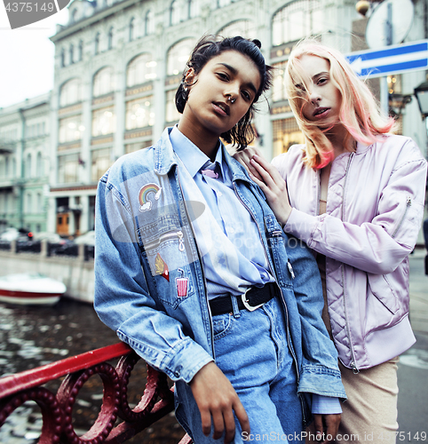 Image of Two diverse race teenage girls infront of university building smiling, having fun, lifestyle real people concept