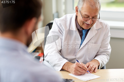 Image of doctor writing prescription for patient at clinic