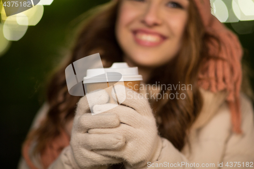 Image of happy woman with coffee over christmas lights