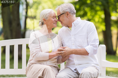 Image of happy senior couple sitting on bench at park