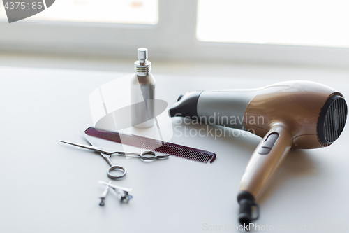 Image of hairdryer, scissors, comb and styling hair spray