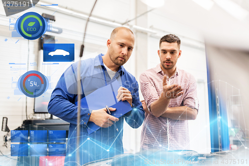 Image of auto mechanic with clipboard and man at car shop