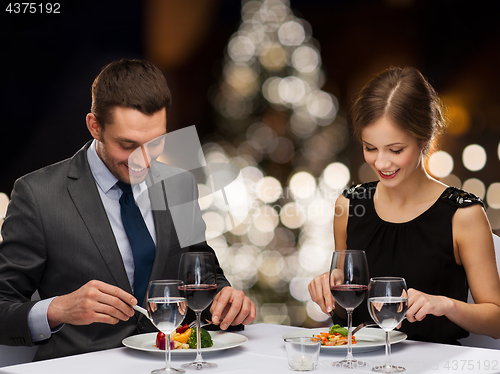 Image of smiling couple eating at christmas restaurant