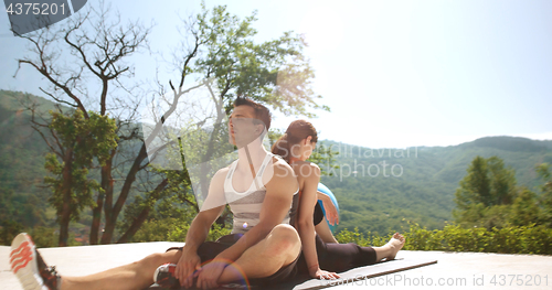 Image of Couple Doing Stretching Exercises Together in front of luxury vi