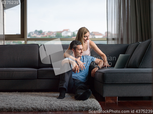 Image of Attractive Couple Using A Laptop on couch