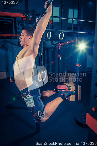 Image of Concept: power, strength, healthy lifestyle, sport. Powerful attractive muscular man at CrossFit gym