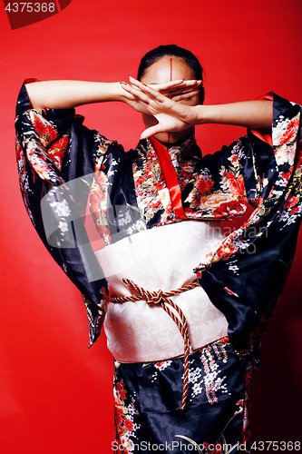 Image of young pretty geisha on red background posing in kimono, oriental people concept close up