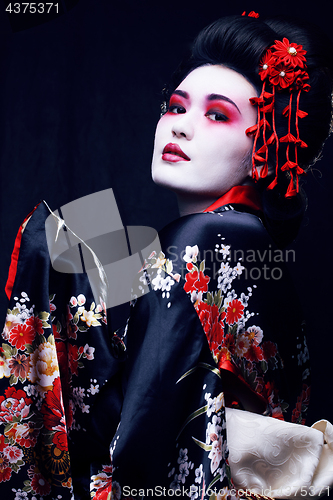 Image of young pretty geisha in kimono with sakura and decoration