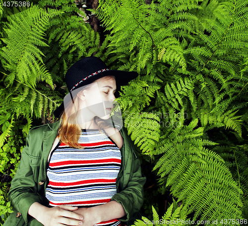 Image of Pretty young blond girl hipster in hat among fern, vacation in green forest, lifestyle fashion people concept 