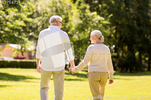 Image of happy senior couple walking at summer park