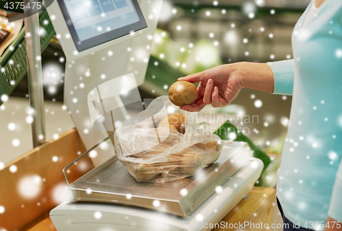 Image of customer with potatoes on scale at grocery store