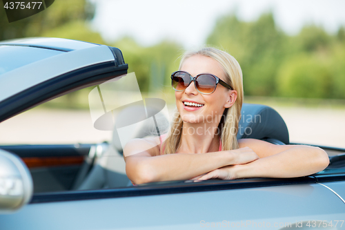 Image of happy young woman in convertible car