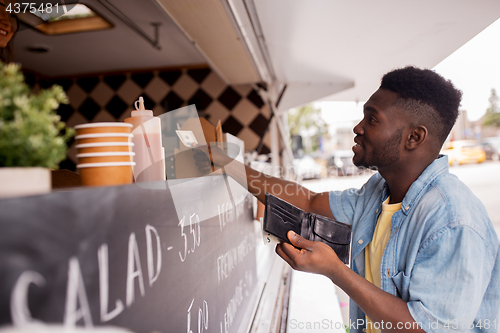 Image of african american man buying wok at food truck