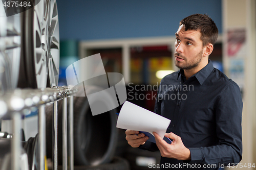 Image of auto business owner and wheel rims at car service