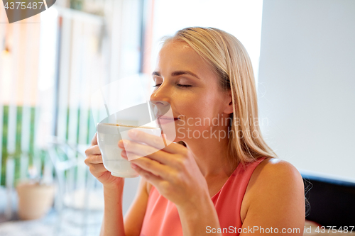 Image of close up of woman drinking coffee at restaurant