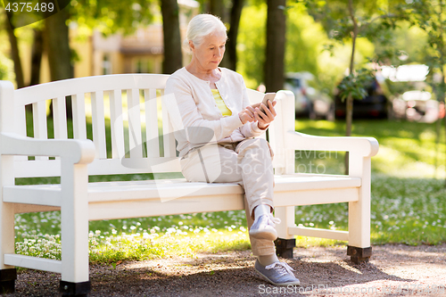 Image of senior woman with smartphone at summer park