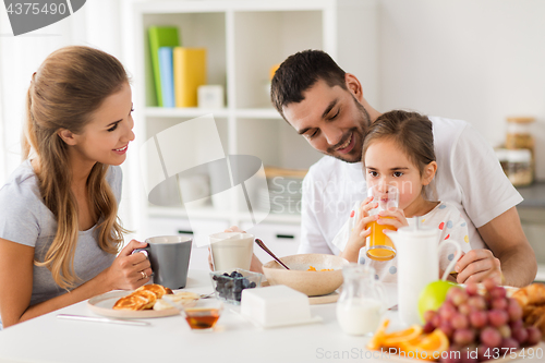 Image of happy family having breakfast at home