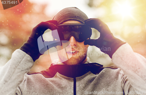 Image of sports man with ski goggles in winter outdoors