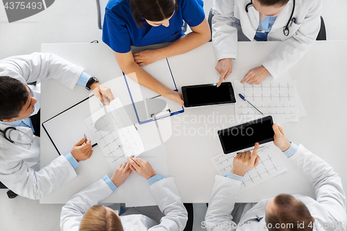 Image of doctors with cardiograms and tablet pc at hospital