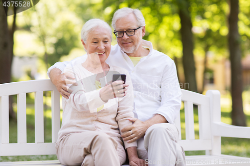 Image of senior couple taking selfie by smartphone at park