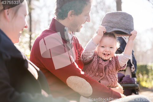 Image of Young family with cheerful child in the park.